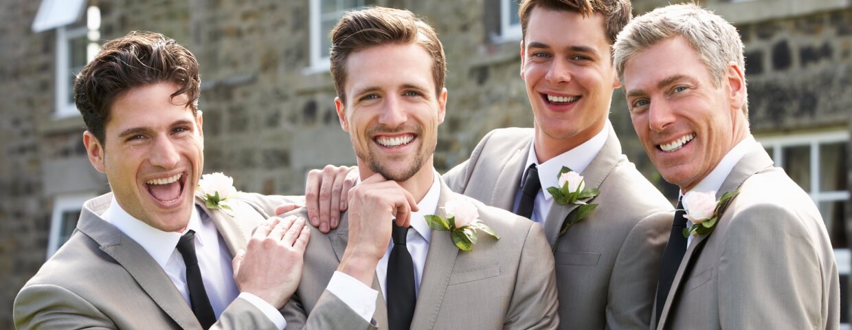 Groom and groomsmen wedding photo, dressed in suits, smiling 
