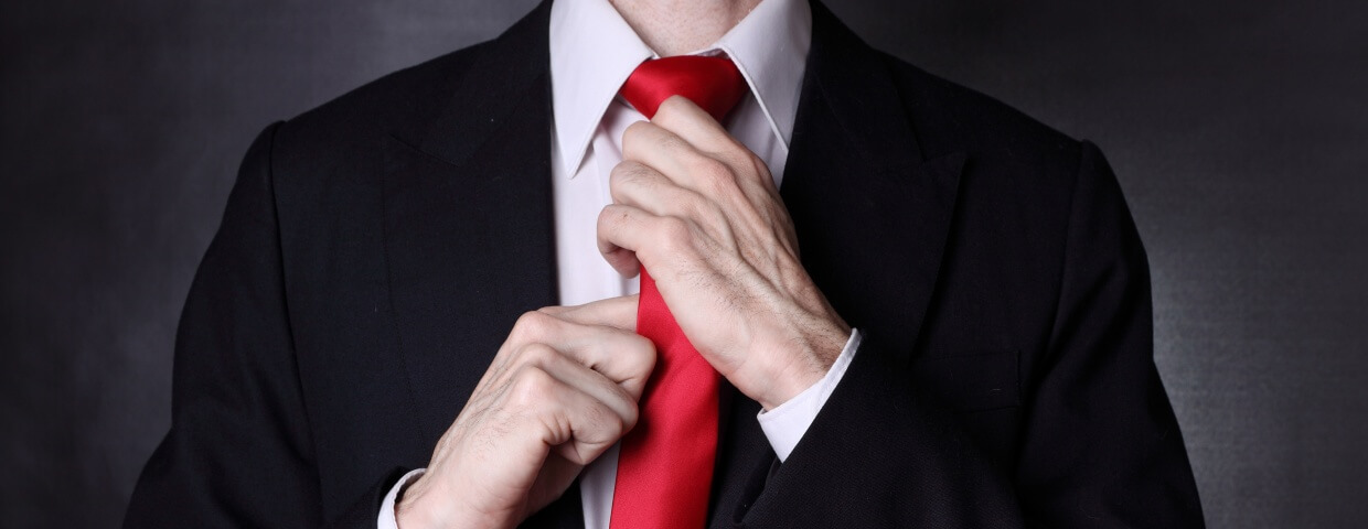 closeup of man tying knot in necktie