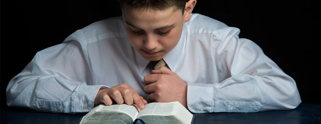 young lds missionary in shirt and tie studying scriptures preparing for misison