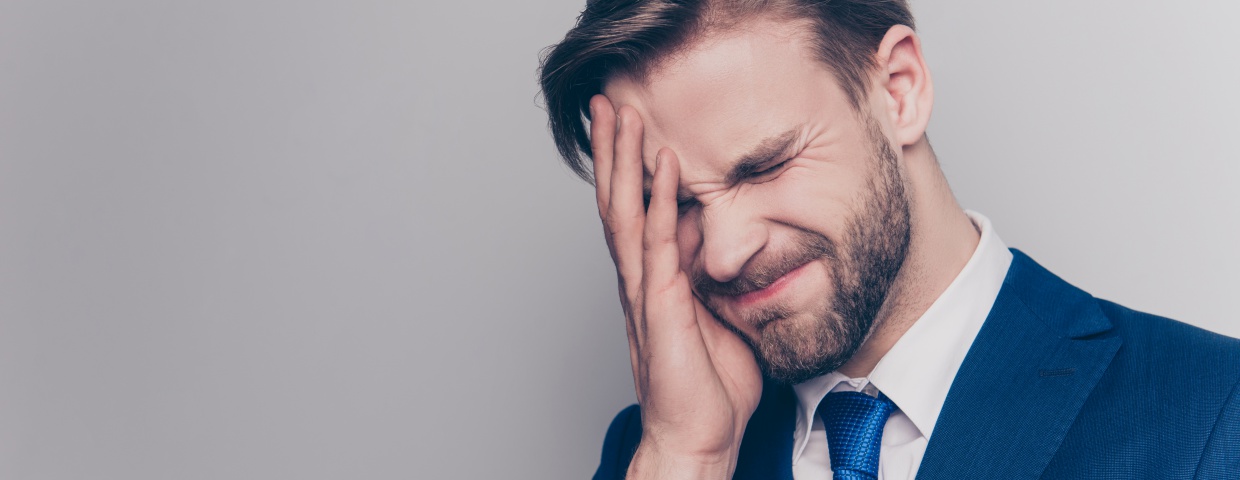 man with hand on his face, frustrated 