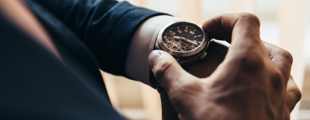 closeup of man checking the time on his wrist watch