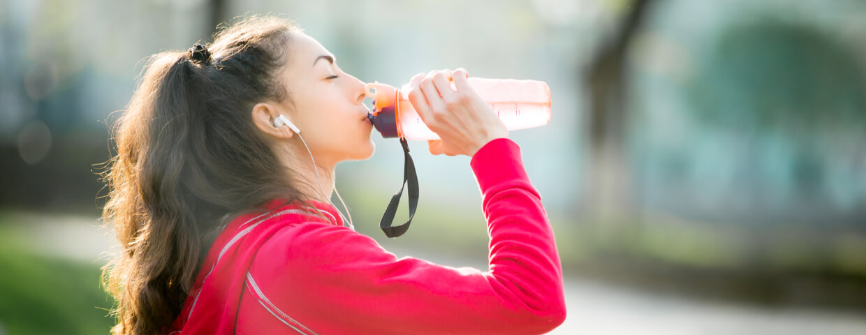 young adult female drinking water after exercise, health concept