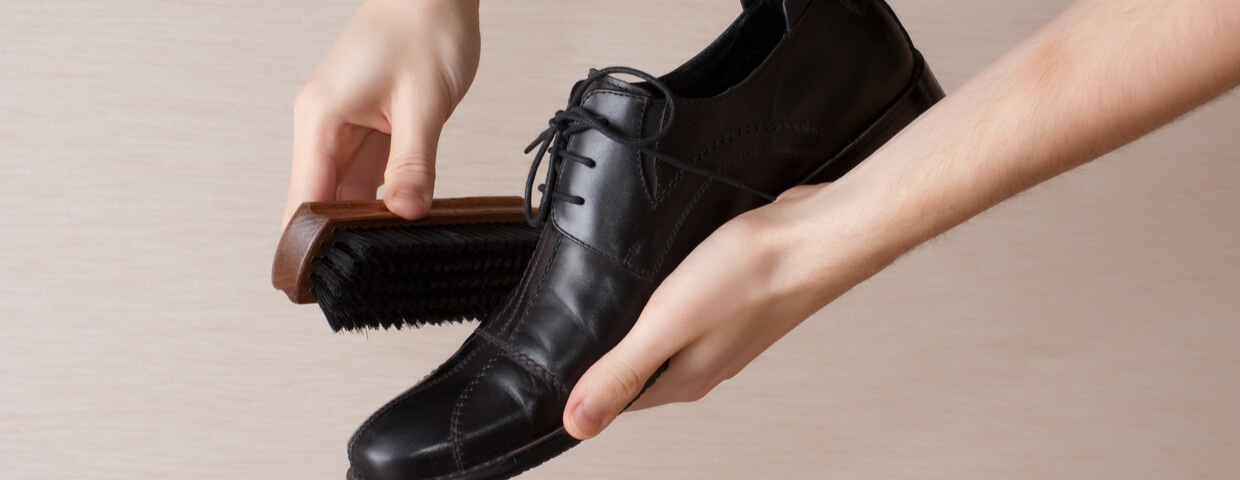 man cleaning and polishing dress shoe